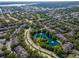 Beautiful aerial view of an upscale residential area with winding roads, lush landscaping, and serene pond with a fountain at 2173 Tuscany Trce # 8, Palm Harbor, FL 34683