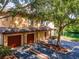 Exterior of home with garage, and mature landscaping and trees by the pond at 2173 Tuscany Trce # 8, Palm Harbor, FL 34683
