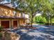 Exterior of the home showing the garage and proximity to the pond and mature trees at 2173 Tuscany Trce # 8, Palm Harbor, FL 34683