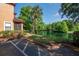 Lakeside condo complex with manicured lawn and screened patios near parking spots at 2173 Tuscany Trce # 8, Palm Harbor, FL 34683