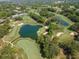 Scenic aerial of a well-manicured golf course with serene lakes, lush green fairways, and tree-lined surroundings at 2173 Tuscany Trce # 8, Palm Harbor, FL 34683