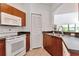 Charming kitchen with white appliances and wood cabinetry provides a cozy cooking space at 2173 Tuscany Trce # 8, Palm Harbor, FL 34683