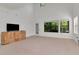 Bright living room featuring plush carpeting, wooden entertainment center, and large windows overlooking the green landscape at 2173 Tuscany Trce # 8, Palm Harbor, FL 34683