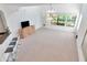 Bright living room featuring plush carpeting, modern light fixture, and large windows overlooking the green landscape at 2173 Tuscany Trce # 8, Palm Harbor, FL 34683