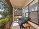 Relaxing screened patio with wicker furniture offers views of a tranquil lake and fountain at 2173 Tuscany Trce # 8, Palm Harbor, FL 34683