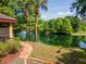 Apartment community featuring a pond, palm trees, and lush landscaping and sidewalk at 2173 Tuscany Trce # 8, Palm Harbor, FL 34683