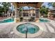 Inviting community pool and hot tub area with ample lounge seating and lush landscaping at 2173 Tuscany Trce # 8, Palm Harbor, FL 34683