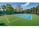 Well-maintained tennis court with vibrant blue and green surface, surrounded by lush greenery at 2173 Tuscany Trce # 8, Palm Harbor, FL 34683