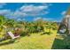 Spacious backyard with lush landscaping, a relaxing swing chair, and scenic lake views, offering a peaceful retreat at 2247 Midnight Pearl Dr, Sarasota, FL 34240
