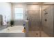 Bright bathroom features a soaking tub and separate glass-enclosed shower with gray tiling at 2247 Midnight Pearl Dr, Sarasota, FL 34240