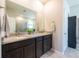 Double sink vanity with dark cabinets and gray tile flooring in this bathroom at 2247 Midnight Pearl Dr, Sarasota, FL 34240