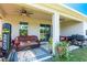 Inviting covered patio featuring a brown leather sofa, ceiling fan, and a grill, perfect for outdoor relaxation and entertaining at 2247 Midnight Pearl Dr, Sarasota, FL 34240