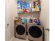 Spacious laundry room with dual washer/dryer units and shelving at 2247 Midnight Pearl Dr, Sarasota, FL 34240