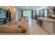 Open living space featuring a large sectional sofa, a kitchen bar and sliding glass doors to the yard at 2247 Midnight Pearl Dr, Sarasota, FL 34240