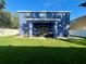 Spacious backyard featuring a covered patio and lush green lawn at 2325 Via Bella Blvd, Land O Lakes, FL 34639