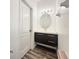 Modern half-bath with dark wood vanity, oval mirror, and unique lighting fixture at 2325 Via Bella Blvd, Land O Lakes, FL 34639