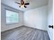 This bedroom has a ceiling fan, window, and grey wood-style laminate flooring at 2325 Via Bella Blvd, Land O Lakes, FL 34639