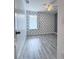 Inviting bedroom with unique accent wall and grey wood-style laminate flooring at 2325 Via Bella Blvd, Land O Lakes, FL 34639