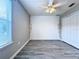 An unfurnished bedroom featuring light gray vinyl flooring, a ceiling fan, and white walls at 2325 Via Bella Blvd, Land O Lakes, FL 34639