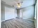 A bedroom featuring light grey vinyl plank flooring, a ceiling fan, and a large closet at 2325 Via Bella Blvd, Land O Lakes, FL 34639