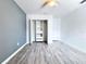 Bedroom with closet featuring built-in shelving and grey wood-style laminate flooring at 2325 Via Bella Blvd, Land O Lakes, FL 34639