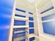 Spacious walk-in closet with custom shelving, drawers and blue accents at 2325 Via Bella Blvd, Land O Lakes, FL 34639