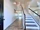 Bright foyer with hardwood floors and a staircase featuring white risers and black handrail at 2325 Via Bella Blvd, Land O Lakes, FL 34639