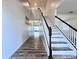 Hallway showcasing white stairs, a black banister, and wood-style floors at 2325 Via Bella Blvd, Land O Lakes, FL 34639