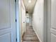 Long hallway with wood-look floors, white walls, and doors at 2325 Via Bella Blvd, Land O Lakes, FL 34639