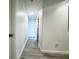 Bright hallway with grey wood flooring, white walls, leading to rooms in the home at 2325 Via Bella Blvd, Land O Lakes, FL 34639
