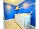 Bright laundry room with new washer and dryer and shelving at 2325 Via Bella Blvd, Land O Lakes, FL 34639