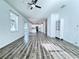 Open-concept living space featuring wood-look floors and a view into the modern kitchen at 2325 Via Bella Blvd, Land O Lakes, FL 34639