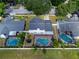 Aerial shot of a house with a screened pool, white fence, and green lawn nestled in a residential neighborhood at 2619 Green Valley St, Valrico, FL 33596