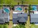 Aerial view of a home with a backyard featuring a screened-in pool, lush greenery, and a white fence at 2619 Green Valley St, Valrico, FL 33596