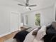 Bedroom features neutral paint, wood floors, ceiling fan, and windows at 2619 Green Valley St, Valrico, FL 33596