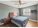 Bedroom features gray walls, wood floors, ceiling fan, window and flat screen television at 2619 Green Valley St, Valrico, FL 33596