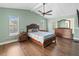 Spacious main bedroom featuring wood floors, plentiful natural light and a comfortable bed at 2619 Green Valley St, Valrico, FL 33596