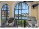 Modern gym featuring treadmills and views of the pool and tropical landscaping at 2705 Via Murano # 127, Clearwater, FL 33764