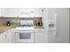Bright kitchen with granite counters, white cabinets and appliances at 2705 Via Murano # 127, Clearwater, FL 33764