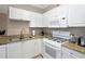 Well-lit kitchen offers granite countertops, white cabinets, and modern gas appliances at 2705 Via Murano # 127, Clearwater, FL 33764