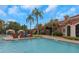 Beautiful community pool surrounded by palm trees, lounge chairs, and covered seating at 2705 Via Murano # 127, Clearwater, FL 33764