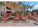 Outdoor lounge area with sun loungers and umbrella near the community pool at 2705 Via Murano # 127, Clearwater, FL 33764
