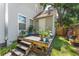 Back porch entryway with gray siding and wood steps, accented by potted plants and greenery at 2911 N Jefferson St, Tampa, FL 33602
