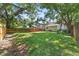 Expansive, grassy backyard enclosed by a wooden fence and shaded by mature trees, ideal for outdoor enjoyment at 2911 N Jefferson St, Tampa, FL 33602