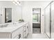 Bathroom featuring white double vanity with marble countertops and view of bedroom at 30273 Marquette Ave, Wesley Chapel, FL 33545