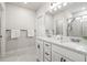 Bathroom featuring white double vanity with marble countertops and glass enclosed shower at 30273 Marquette Ave, Wesley Chapel, FL 33545