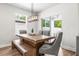 Dining area featuring a rustic wood table, stylish chairs and sliding doors to a screened lanai at 30273 Marquette Ave, Wesley Chapel, FL 33545