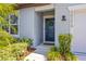 Inviting entrance with a stylish navy blue door, decorative wreath, and well-maintained landscaping at 30273 Marquette Ave, Wesley Chapel, FL 33545