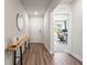Hallway featuring hardwood floors, modern decor and leads into an office space with large window at 30273 Marquette Ave, Wesley Chapel, FL 33545