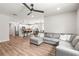 Open concept living space with modern gray sofa flowing into a bright kitchen with island seating at 30273 Marquette Ave, Wesley Chapel, FL 33545